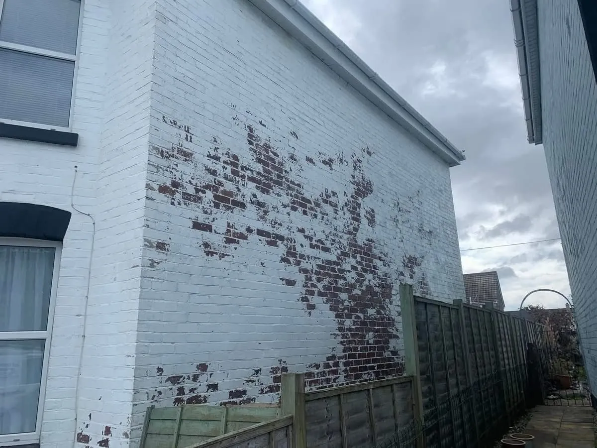 Peeling paint on a brick wall before redecoration in St Austell